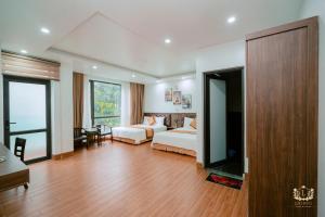 a hotel room with two beds and a television at Ks Luxhotel flc sầm sơn in Sầm Sơn +3 photos