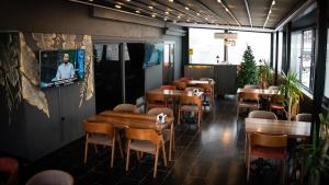 a restaurant with tables and chairs and a tv on the wall at COMFORT HOUSE HOTEL in Pelitli