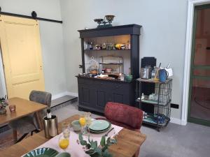 a dining room with a table and a cabinet at Noardlik B&B in Birdaard +13 photos