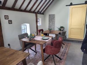 a dining room with tables and chairs and a yellow door at Noardlik B&B in Birdaard