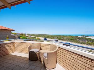 a balcony with chairs and a view of the ocean at Ocean Reef Marina by the Sea 4BR plus Study plus in Perth