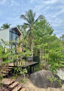 a house on the beach with a bench and trees at Duplex House in Chaloklum +16 photos