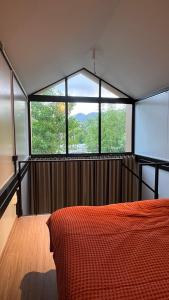 a bedroom with a bed and a large window at Duplex House in Chaloklum