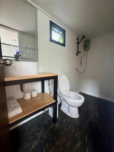 a bathroom with a white toilet and a sink at Duplex House in Chaloklum