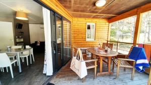 a dining room with a table and chairs on a porch at ZEcamping 2 avec piscine restaurant vue sur le village de Saint Auban in Briançonnet