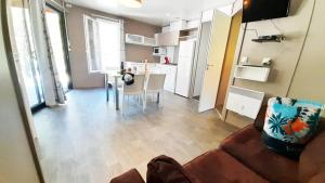 a living room with a couch and a kitchen at ZEcamping 2 avec piscine restaurant vue sur le village de Saint Auban in Briançonnet