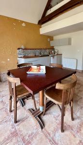 a kitchen with a wooden table and chairs at Gîte La Thibaud in Lavernat