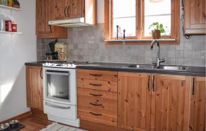 a kitchen with wooden cabinets and a sink and a stove at Awesome Home In Sölvesborg With Wifi in Sölvesborg