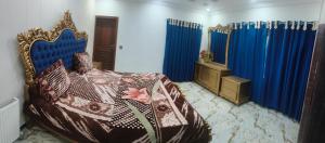 a bedroom with a bed and blue curtains at Koh E Sukoon Apartments in Patriata