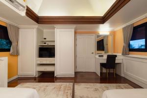a bedroom with a desk and a table with a chair at J Valley Resort in Pong Yaeng +33 photos