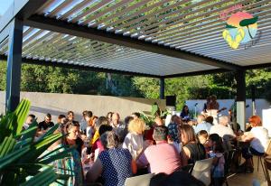 a crowd of people sitting at tables under a pergola at ZEcamping 3 étoiles à 4km de la plage piscine chiens acceptés jacuzzi in Bormes-les-Mimosas