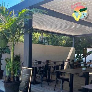 a patio with tables and chairs under a pergola at ZEcamping 3 étoiles à 4km de la plage piscine chiens acceptés jacuzzi in Bormes-les-Mimosas +78 photos
