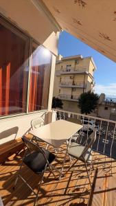 a balcony with a table and chairs and a building at Romance Apartments in Sarandë