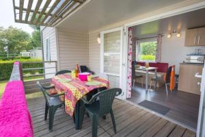 a patio with a table and chairs and a kitchen at ZEcamping 3 étoiles animaux acceptés avec piscine chauffée à Guérande in Guérande