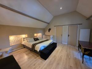 a bedroom with a bed and a desk and a piano at Villa du Marais in Ri