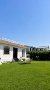 a white house with a picnic table in the yard at Shiv kashi farm luxury 3bhk with big pool in Noida