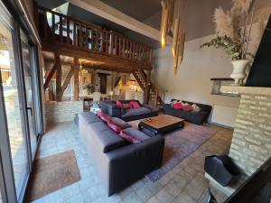 a living room with couches and a table at Villa du Marais in Ri