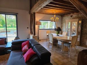 a living room with a couch and a table at Villa du Marais in Ri