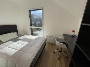 a bedroom with a bed and a desk and a window at Duplex 3 chambres Etoile du sud in Le Lioran