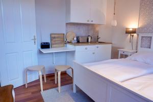 a bedroom with a bed and a kitchen with stools at Ferienwohnung LOTTTALEBEN 2 in Timmendorfer Strand +9 photos