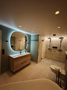 a bathroom with a sink and a mirror and a tub at Vangsgaarden Gjestgiveri in Aurland +70 photos