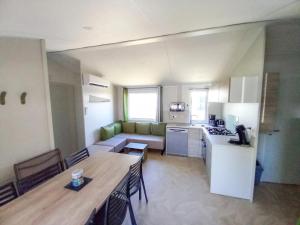 a kitchen and living room with a table and a kitchen and a dining room at ZEcamping 3 animaux acceptés club enfant piscine couverte in Prigny