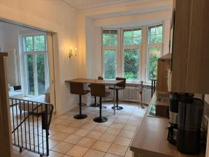 a kitchen with a table and chairs and windows at Wunderschöne 2 Zimmer Wohnung in Wuppertal in Wuppertal +28 photos