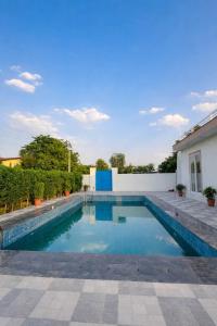 a swimming pool in the backyard of a house at Shiv kashi farm luxury 3bhk with big pool in Noida