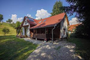 a house with a red roof on a field at Szőcs-birtok - The old house in Izvoare