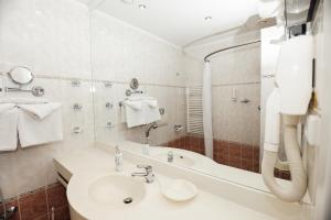 a bathroom with a sink and a bath tub at Hotel Pavlov in Karlovy Vary