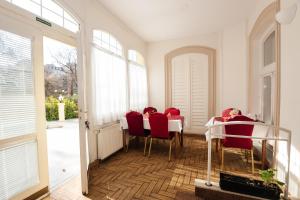 a dining room with red chairs and a table at Hotel Pavlov in Karlovy Vary +68 photos