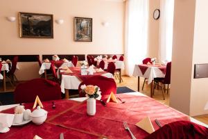 a restaurant with tables and chairs with red table cloth at Hotel Pavlov in Karlovy Vary