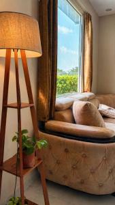 a couch sitting in front of a window at Shiv kashi farm luxury 3bhk with big pool in Noida +13 photos