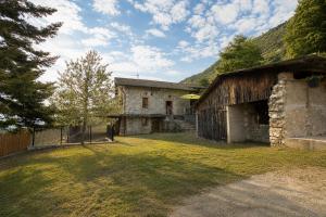 an old barn with a grass yard in front of it at L'évasion authentique du Vercors in Saint-André-en-Royans