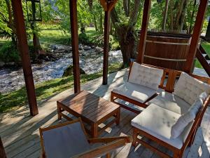 a porch with a couch and chairs and a table at Szőcs-birtok - The old house in Izvoare