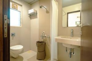 a bathroom with a toilet and a sink and a mirror at Hotel Sitara Residency in Navi Mumbai +49 photos