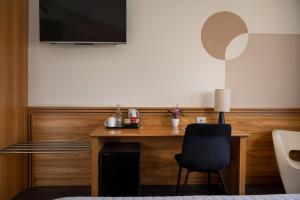 a room with a desk with a chair and a television at Hotel Europa Belluno in Belluno