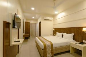 a hotel room with a bed and a television at Hotel Sitara Residency in Navi Mumbai