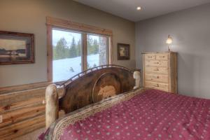 a bedroom with a large wooden bed and a window at Lone View Lodge in Big Sky Mountain Village
