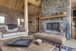 a living room with a stone fireplace in a house at Lone View Lodge in Big Sky Mountain Village