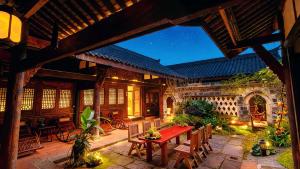 an outdoor patio with a table and chairs at night at Nan Court - Nanyuan,Leshan in Leshan