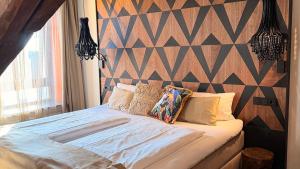 a bedroom with a large bed with a geometric wall at Boutique Hotel K7 in Bad Nauheim