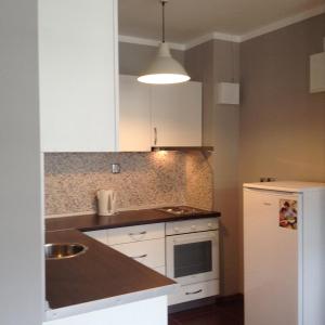 a kitchen with white cabinets and a white refrigerator at Apartment Sredetz in Sofia