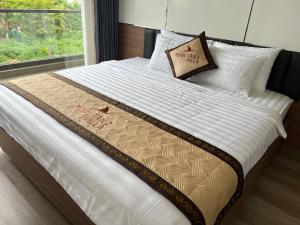 a large bed with white sheets and a pillow on it at Minhtan2 villa in Dong Hoi