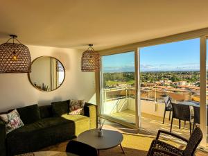 a living room with a couch and a large window at La Tour Myra in Valras-Plage