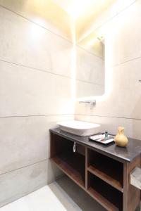 a bathroom with a sink and a mirror at Hotel Gangotri Suites in Haridwār +30 photos