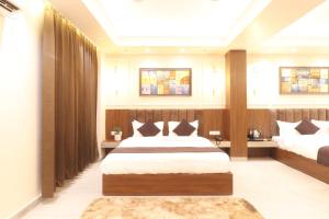 a bedroom with two beds in a room at Hotel Gangotri Suites in Haridwār