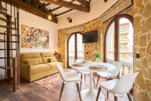 a living room with a couch and a table and chairs at Los Balcones de San Juan in Salamanca