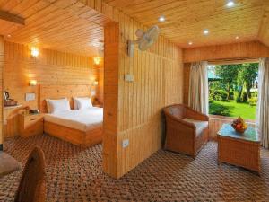 a bedroom with a bed and a chair and a window at Hotel Mirage in Srinagar +148 photos