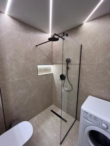 a bathroom with a shower and a washing machine at Georges House in Nea Moudania